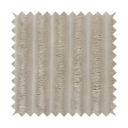 A warm, beige-toned textile featuring a repeating, vertical channel-tufted pattern. The fabric alternates between thick, high-pile plush bands and thin, compressed vertical channels.