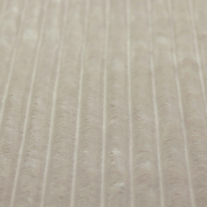 A warm, beige-toned textile featuring a repeating, vertical channel-tufted pattern. The fabric alternates between thick, high-pile plush bands and thin, compressed vertical channels.