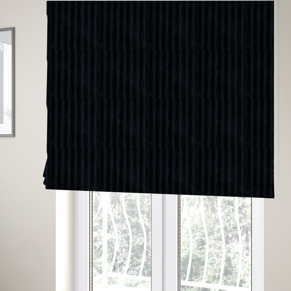 The fabric used to create these Roman blinds is a deep black textile featuring a repeating, vertical channel-tufted pattern. The fabric alternates between thick, high-pile plush bands and thin, compressed vertical channels.