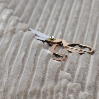 A grey textile featuring a repeating, vertical channel-tufted pattern that alternates between soft, high-pile bands and narrow, flat lines.