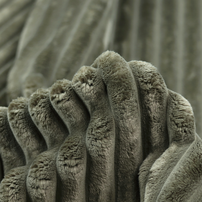 A muted, olive green textile featuring a repeating, vertical channel-tufted pattern that alternates between soft, high-pile bands and narrow, flat lines.