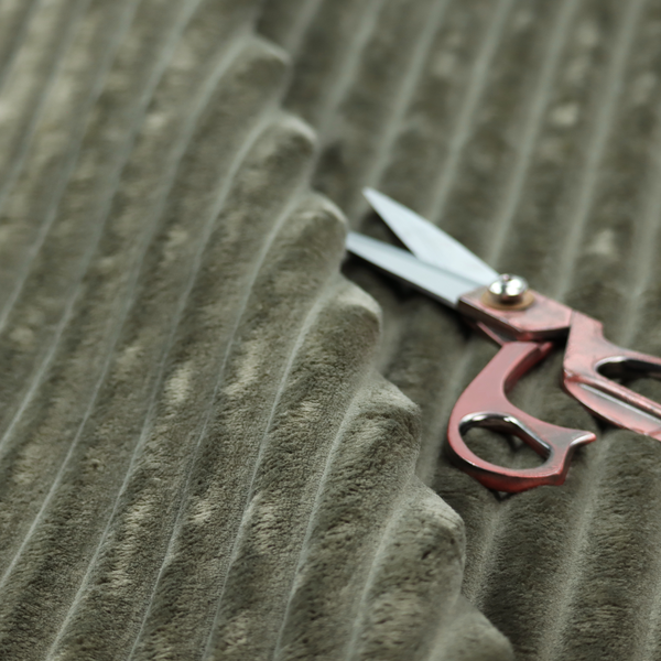 A muted, olive green textile featuring a repeating, vertical channel-tufted pattern that alternates between soft, high-pile bands and narrow, flat lines.