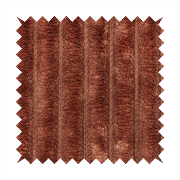 A orange rust, vertically ribbed, channel-tufted plush fabric with a soft, fuzzy texture.