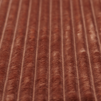 A orange rust, vertically ribbed, channel-tufted plush fabric with a soft, fuzzy texture.