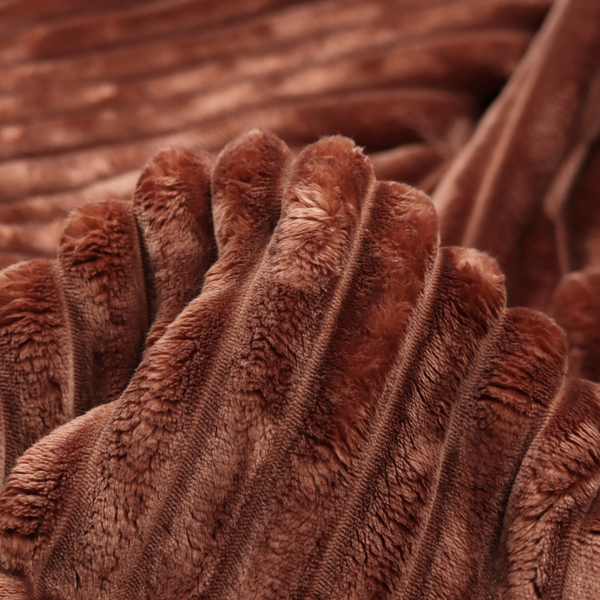 A orange rust, vertically ribbed, channel-tufted plush fabric with a soft, fuzzy texture.