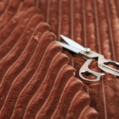 A orange rust, vertically ribbed, channel-tufted plush fabric with a soft, fuzzy texture.