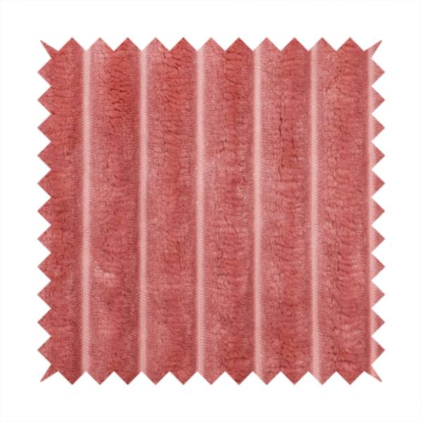 A pink, vertically ribbed, channel-tufted plush fabric.