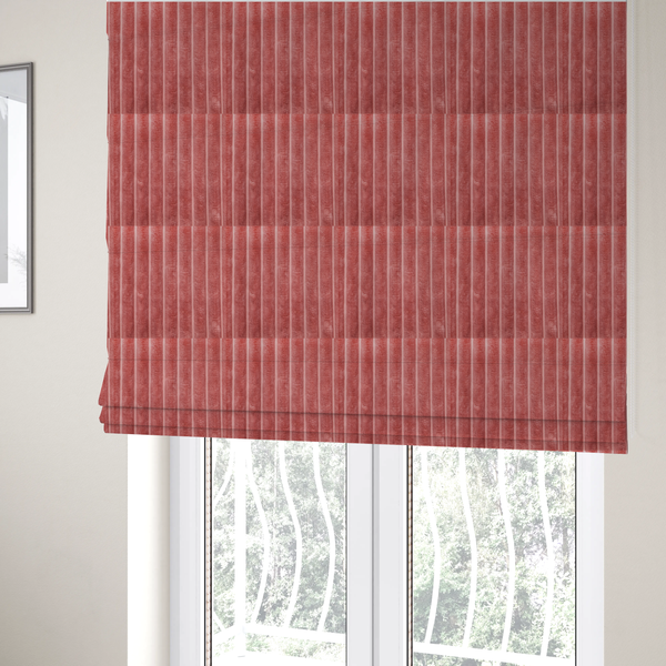 The fabric used to create these Roman blinds is a pink, vertically ribbed, channel-tufted plush fabric.