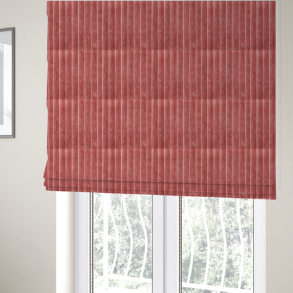 The fabric used to create these Roman blinds is a pink, vertically ribbed, channel-tufted plush fabric.