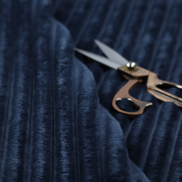 A navy blue, vertically ribbed plush fabric.