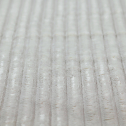 A light grey, vertically ribbed, channel-tufted plush fabric.