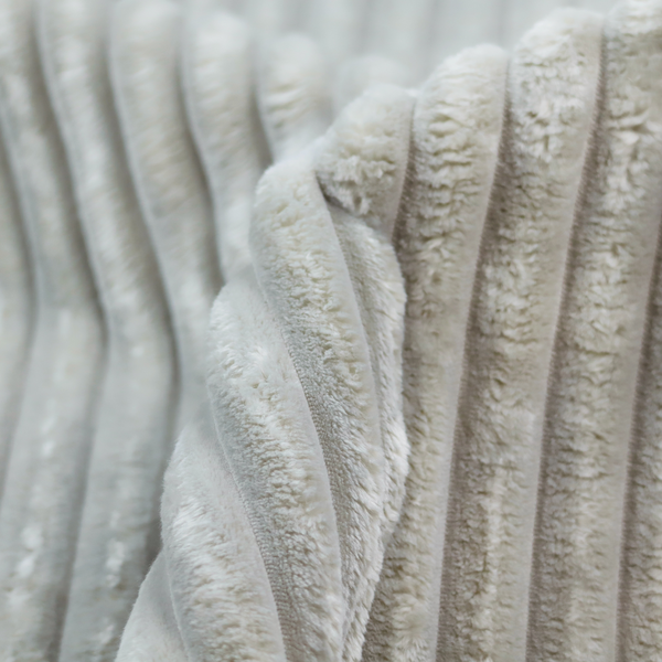 A light grey, vertically ribbed, channel-tufted plush fabric.