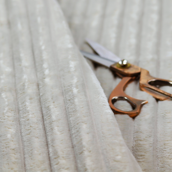 A light grey, vertically ribbed, channel-tufted plush fabric.