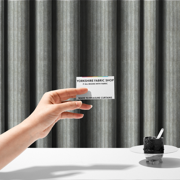 The fabric used to create these made-to-measure curtains is a light grey, vertically ribbed, channel-tufted plush fabric.