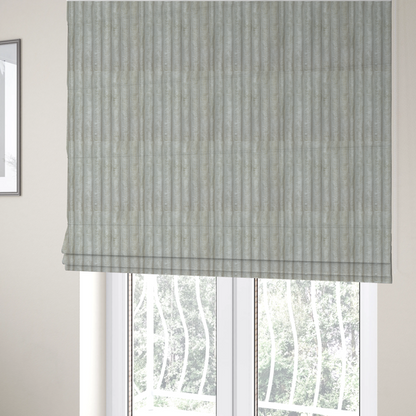 The fabric used to create these Roman blinds is a light grey, vertically ribbed, channel-tufted plush fabric.