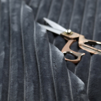 A charcoal grey, vertically ribbed, channel-tufted plush fabric.