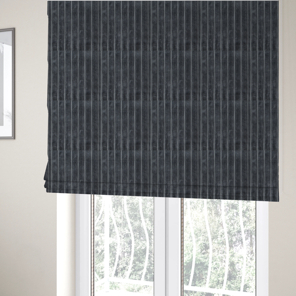 The fabric used to create these Roman blinds is a charcoal grey, vertically ribbed, channel-tufted plush fabric.