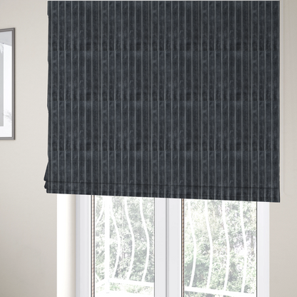 The fabric used to create these Roman blinds is a charcoal grey, vertically ribbed, channel-tufted plush fabric.