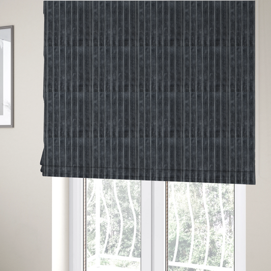 The fabric used to create these Roman blinds is a charcoal grey, vertically ribbed, channel-tufted plush fabric.