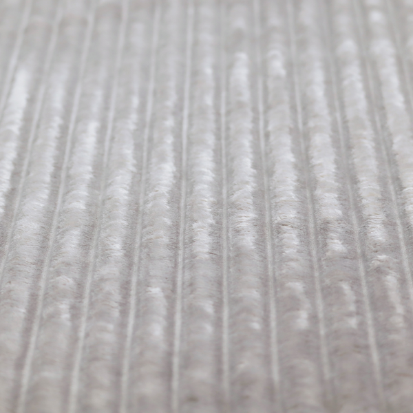A silver vertically ribbed, channel-tufted plush fabric.