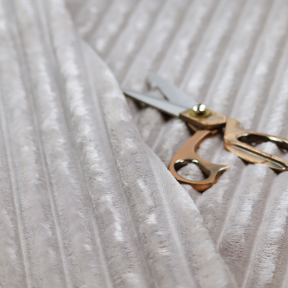 A silver vertically ribbed, channel-tufted plush fabric.