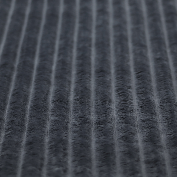 A charcoal grey, vertically ribbed, channel-tufted plush fabric.