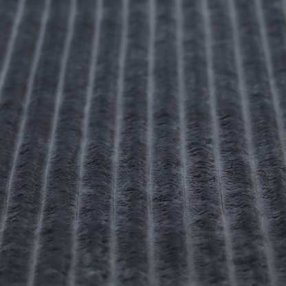 A charcoal grey, vertically ribbed, channel-tufted plush fabric.