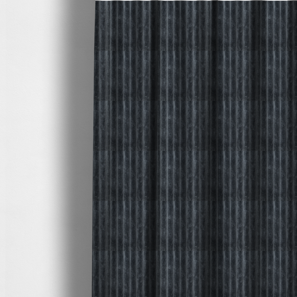 The fabric used to create these made-to-measure curtains is a charcoal grey, vertically ribbed, channel-tufted plush fabric.