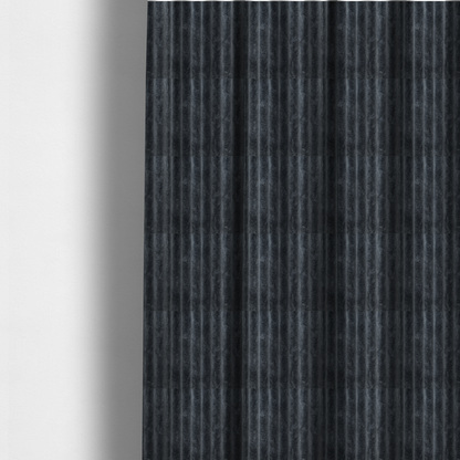 The fabric used to create these made-to-measure curtains is a charcoal grey, vertically ribbed, channel-tufted plush fabric.
