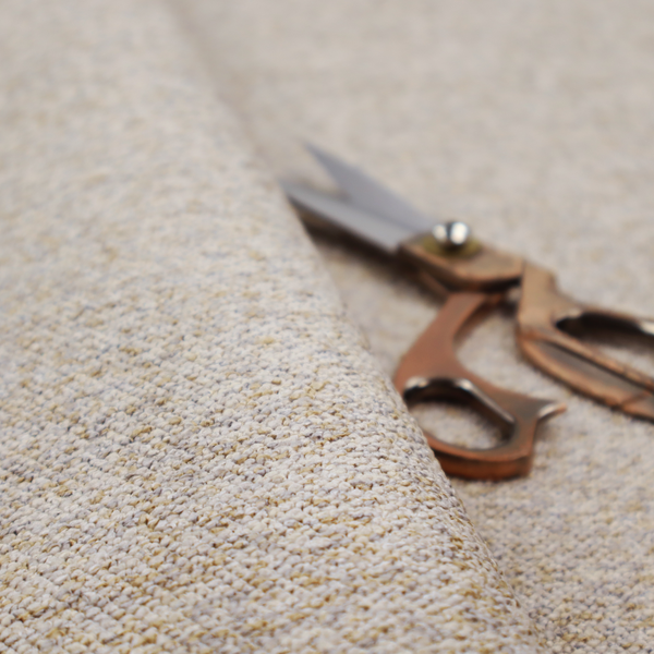 A cream, light grey, and subtle mustard yellow textured upholstery fabric.