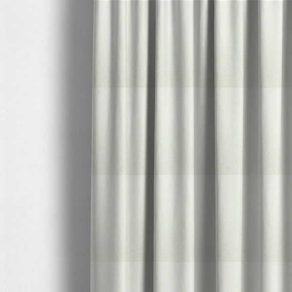 The fabric used to create these made-to-measure curtains is a bright off-white textured upholstery fabric with a clean, light weave.