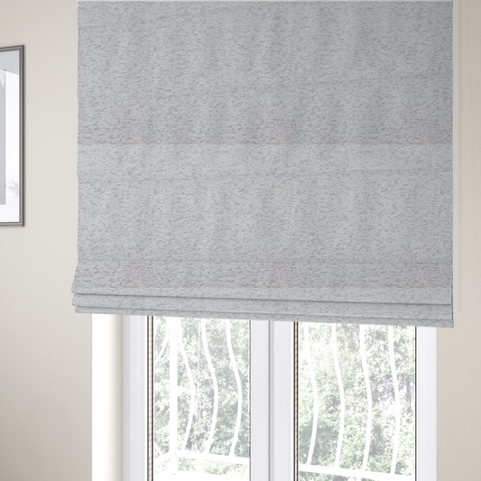 The fabric used to create these Roman blinds is a light cool-toned grey and white blend textured upholstery fabric.