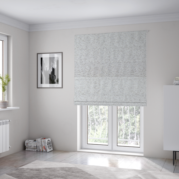 The fabric used to create these Roman blinds is a light cool-toned grey and white blend textured upholstery fabric.