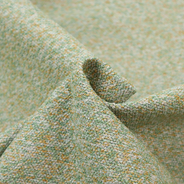 A pale sage green, soft yellow, and white textured upholstery fabric.