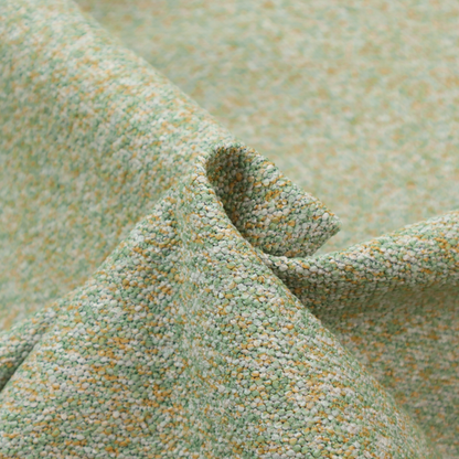 A pale sage green, soft yellow, and white textured upholstery fabric.