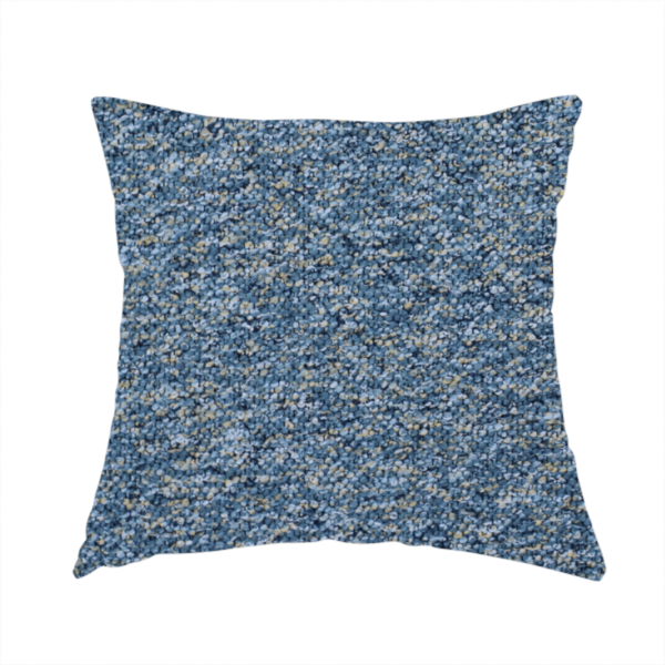The fabric used to create this handmade cushion is a mid-tone blue textured upholstery fabric with subtle cream and yellow flecks.