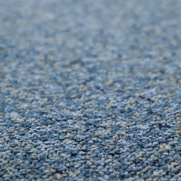 A mid-tone blue textured upholstery fabric with subtle cream and yellow flecks.