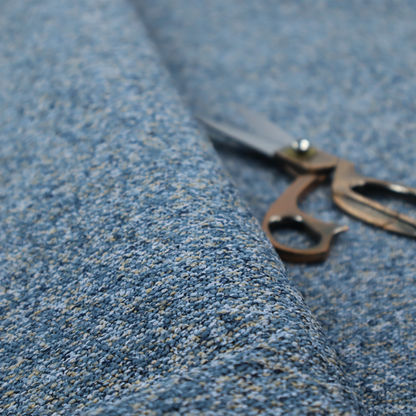 A mid-tone blue textured upholstery fabric with subtle cream and yellow flecks.