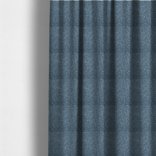 The fabric used to create these made-to-measure curtains is a mid-tone blue textured upholstery fabric with subtle cream and yellow flecks.