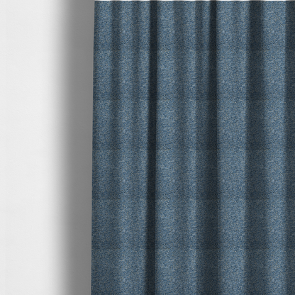 The fabric used to create these made-to-measure curtains is a mid-tone blue textured upholstery fabric with subtle cream and yellow flecks.