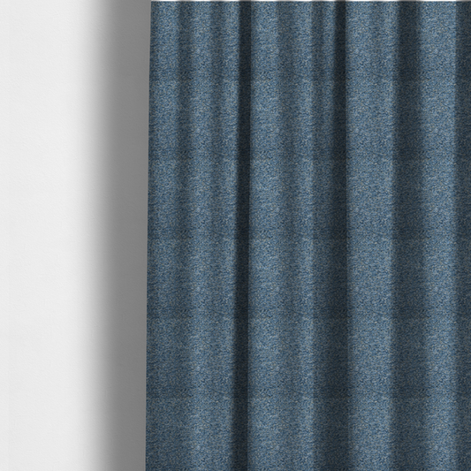 The fabric used to create these made-to-measure curtains is a mid-tone blue textured upholstery fabric with subtle cream and yellow flecks.