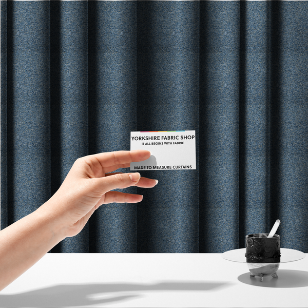 The fabric used to create these made-to-measure curtains is a mid-tone blue textured upholstery fabric with subtle cream and yellow flecks.