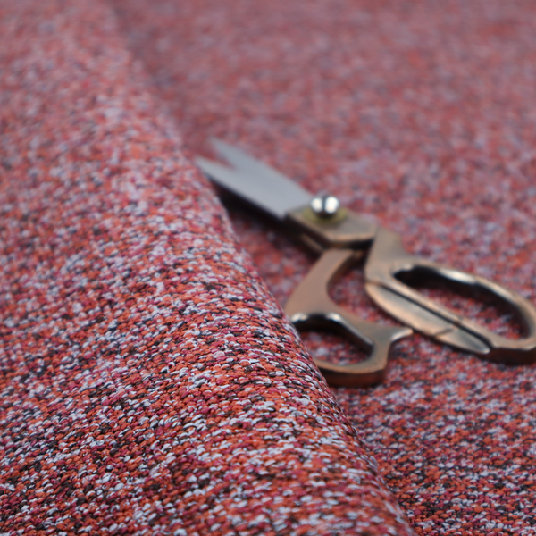 A warm, rustic red and deep terracotta upholstery fabric, showcasing a complex, nubby texture and rich colour variation.