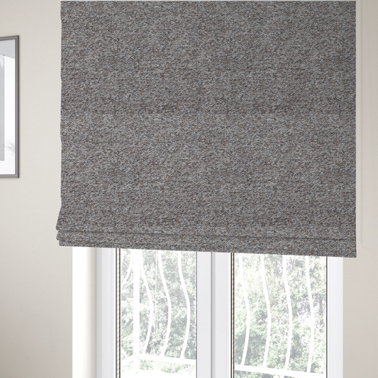 The fabric used to create these Roman blinds is a dark charcoal and slate grey fabric with a dense, nubby weave. The heavy-duty, multi-tonal texture suggests a durable, high-quality material for furniture upholstery.