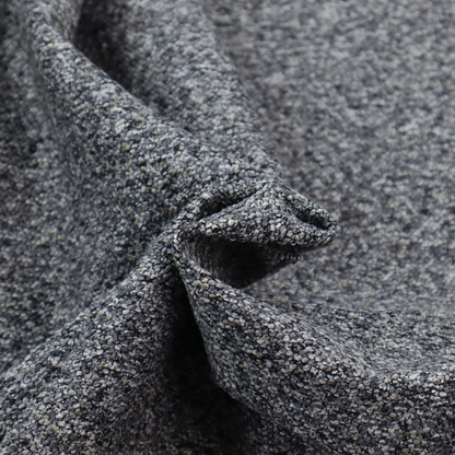 A textured, nubby fabric surface in shades of charcoal, slate, and light grey. The speckled pattern suggests a durable, tightly woven material, ideal for upholstery.