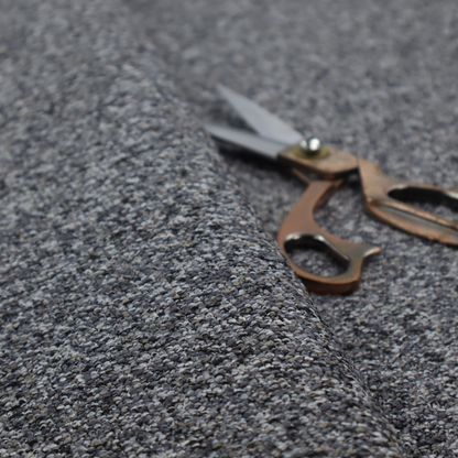 A textured, nubby fabric surface in shades of charcoal, slate, and light grey. The speckled pattern suggests a durable, tightly woven material, ideal for upholstery.