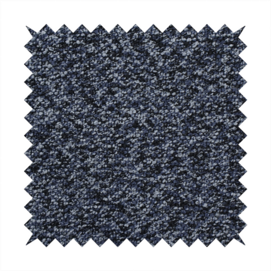 A textured fabric surface. The material features a dense, nubby appearance with a speckled, multi-tonal colour palette of dark navy blue, charcoal, and light grey fibres, characteristic of heavy-duty carpeting or upholstery.