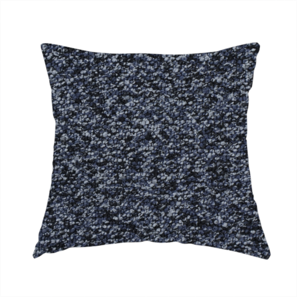 The fabric used to create this handmade cushion is a textured fabric surface. The material features a dense, nubby appearance with a speckled, multi-tonal colour palette of dark navy blue, charcoal, and light grey fibres, characteristic of heavy-duty carpeting or upholstery.