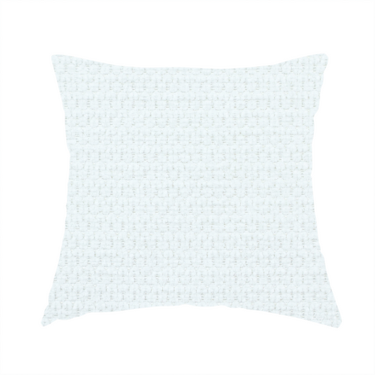 The fabric used to create this handmade cushion is a white, textured fabric with a dense, rhythmic pattern. The material features a honeycomb or waffle-weave structure, where small, uniform raised circles create a grid-like tactile surface. The colour is a bright, cool-toned white, and the subtle shadows within the weave give the fabric a soft, multidimensional appearance.