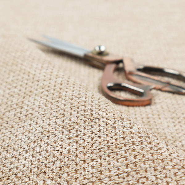 A textured, multi-tonal beige and tan fabric. The material features a tight, intricate weave that creates a pebbled or "seed stitch" appearance. The colour is a warm sand or wheat palette, achieved by interlacing light cream threads with darker tan or straw-coloured fibres, giving the fabric a rich, organic depth.